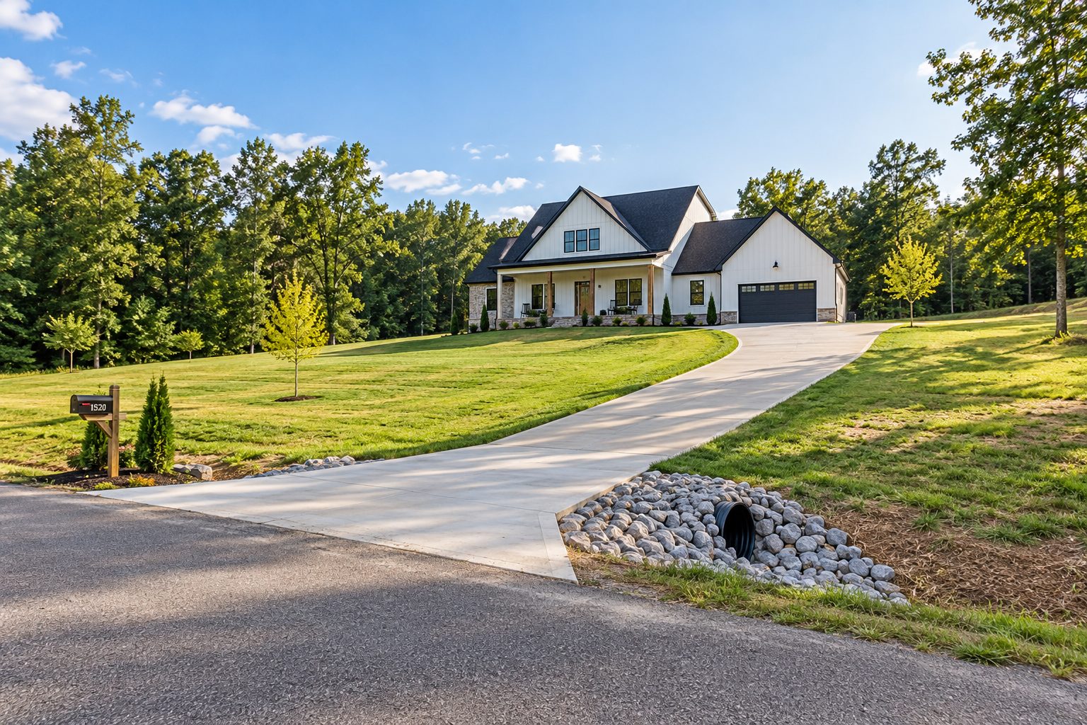 A finished Southaven front elevation photographed from the far side of the yard so the whole home site reads - driveway approach
